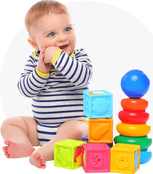 Smiling baby playing with colourful stacking toys